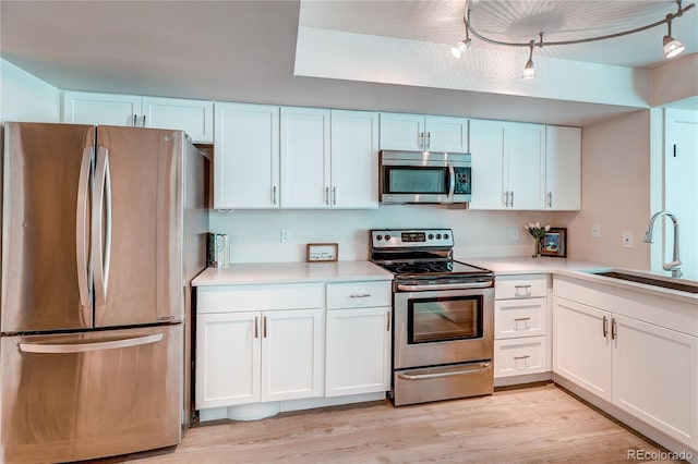 919 S Dawson Way Unit 14, Aurora, CO 80012 - kitchen featuring appliances with stainless steel finishes, white cabinets, light countertops, and light wood-type flooring