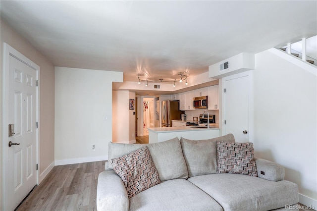 919 S Dawson Way Unit 14, Aurora, CO 80012 - living area with light wood-style floors and rail lighting