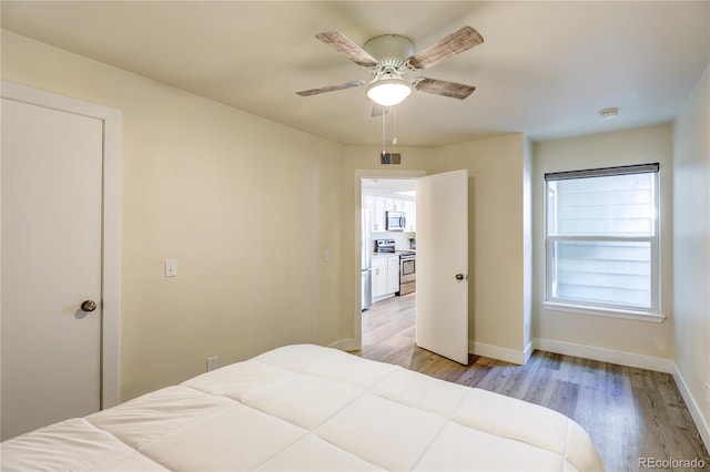 919 S Dawson Way Unit 14, Aurora, CO 80012 - bedroom featuring light wood-style floors, a ceiling fan, and freestanding refrigerator