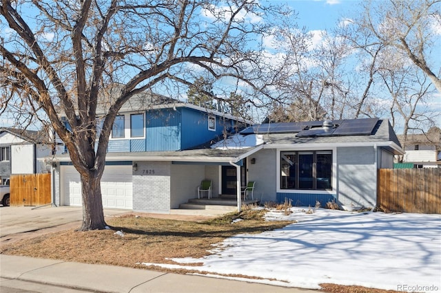 view of front facade with a garage and solar panels