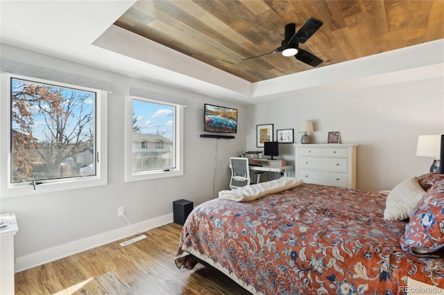 bedroom with a tray ceiling, wooden ceiling, ceiling fan, and hardwood / wood-style flooring