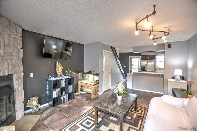 3643 Queen Anne Way, Colorado Springs, CO 80917 - living room with a textured ceiling and a stone fireplace