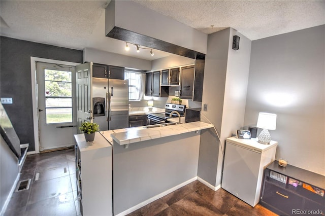 3643 Queen Anne Way, Colorado Springs, CO 80917 - kitchen with appliances with stainless steel finishes, a textured ceiling, light countertops, and a peninsula