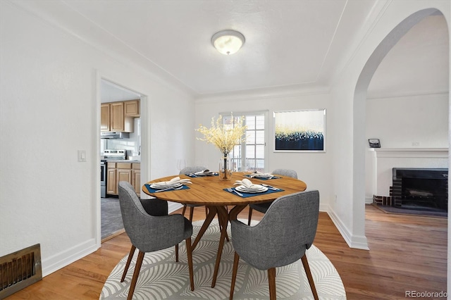 dining room with a fireplace and light hardwood / wood-style flooring