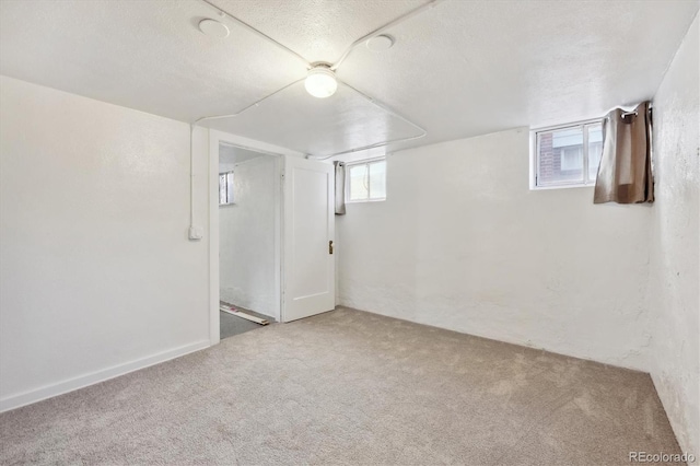 basement featuring a textured ceiling and carpet flooring