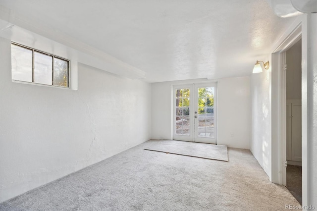 empty room featuring light carpet and french doors