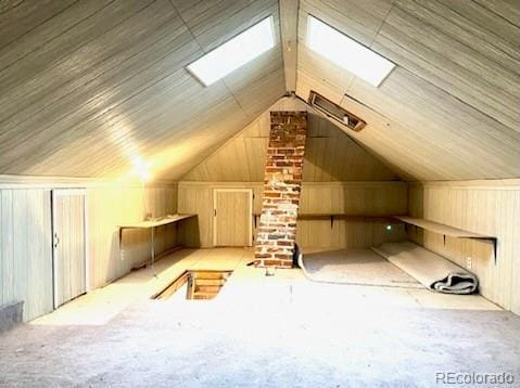 additional living space featuring vaulted ceiling and wood walls