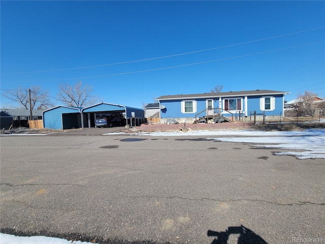 view of front of house with a detached garage and an outbuilding