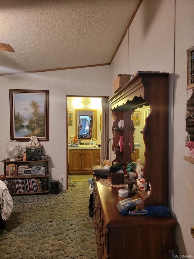 hallway featuring carpet floors, crown molding, a textured ceiling, and lofted ceiling