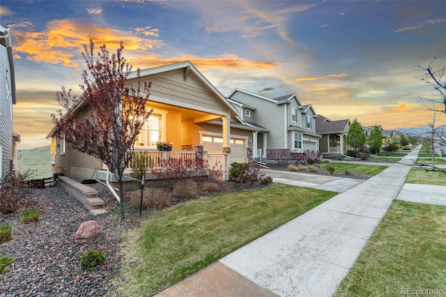 18922 W 84th Ave, Arvada, CO 80007 - view of front facade featuring a garage, concrete driveway, a porch, a yard, and a residential view