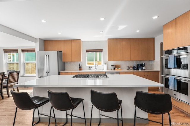 4966 Knox Ct, Denver, CO 80221 - kitchen with stainless steel appliances, a breakfast bar, backsplash, a center island, and recessed lighting