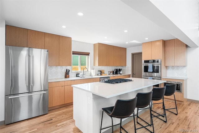 4966 Knox Ct, Denver, CO 80221 - kitchen with stainless steel appliances, a breakfast bar area, light wood-style floors, tasteful backsplash, and recessed lighting