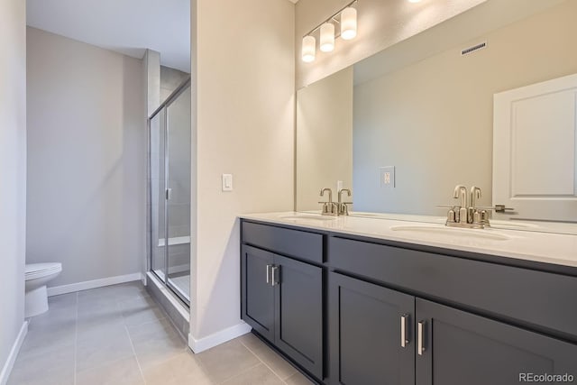 bathroom featuring tile patterned floors, vanity, toilet, and a shower with door