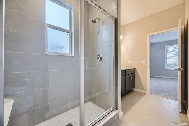 bathroom featuring walk in shower, vanity, plenty of natural light, and tile patterned flooring