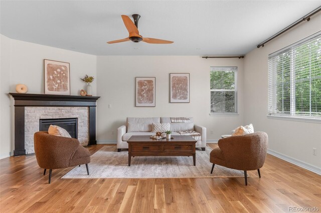 10546 Sundial Rim Rd, Highlands Ranch, CO 80126 - living room with light wood finished floors, a stone fireplace, and baseboards