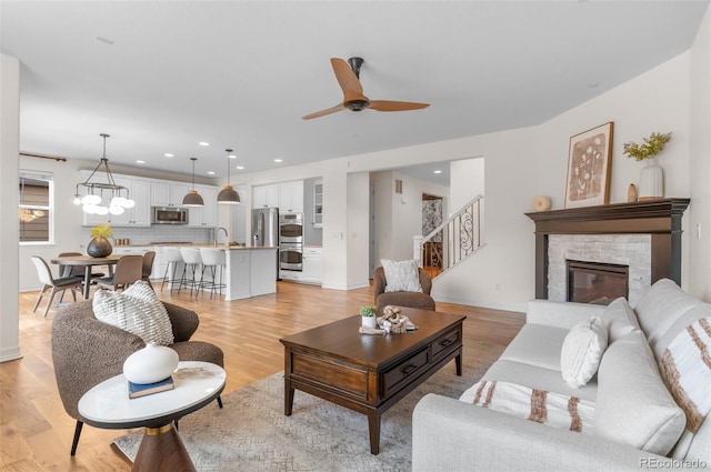 10546 Sundial Rim Rd, Highlands Ranch, CO 80126 - living room with ceiling fan, stairs, light wood finished floors, a fireplace, and recessed lighting