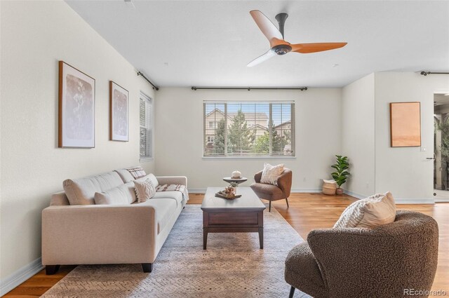 10546 Sundial Rim Rd, Highlands Ranch, CO 80126 - living room featuring light wood-style floors, a ceiling fan, and baseboards