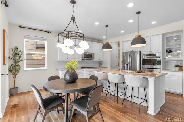10546 Sundial Rim Rd, Highlands Ranch, CO 80126 - dining room with recessed lighting, light wood finished floors, baseboards, and a chandelier