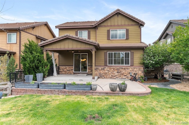 10546 Sundial Rim Rd, Highlands Ranch, CO 80126 - view of front of property featuring a ceiling fan, a patio area, a front lawn, board and batten siding, and stone siding