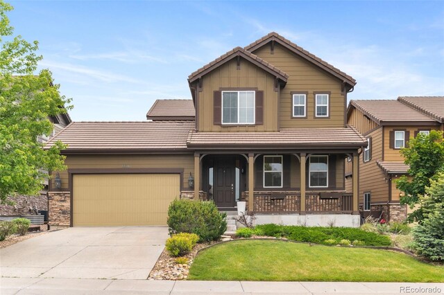 10546 Sundial Rim Rd, Highlands Ranch, CO 80126 - craftsman-style home featuring a tile roof, a porch, driveway, and a garage