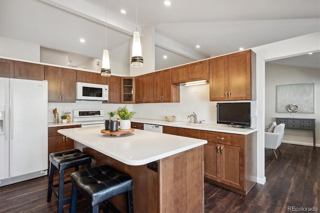 kitchen featuring dark wood-type flooring, lofted ceiling with beams, white appliances, a breakfast bar area, and a kitchen island