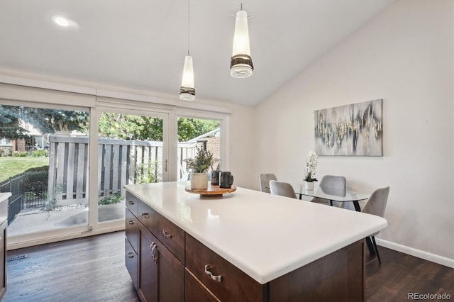 kitchen featuring dark wood-type flooring, pendant lighting, vaulted ceiling, dark brown cabinets, and a kitchen island