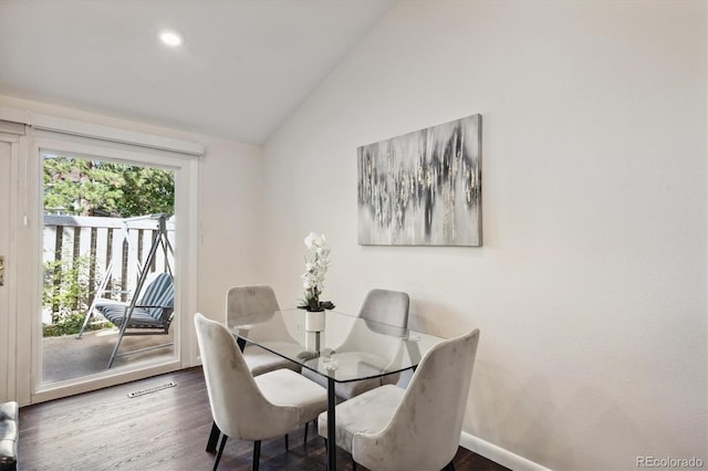 dining space featuring dark hardwood / wood-style flooring and vaulted ceiling