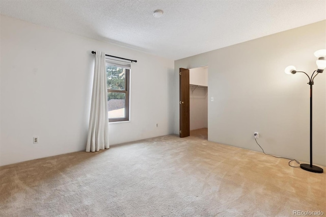 carpeted empty room featuring a textured ceiling