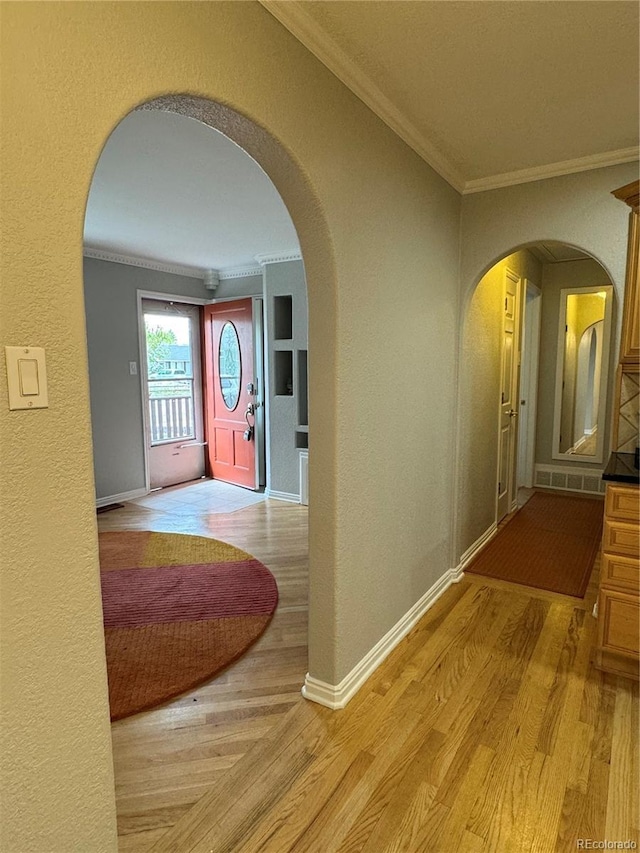 hallway featuring crown molding and light hardwood / wood-style floors