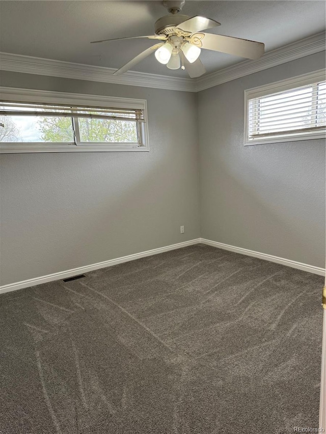 carpeted spare room featuring a wealth of natural light, crown molding, and ceiling fan