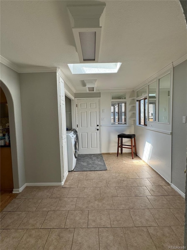 entryway featuring a skylight and ornamental molding