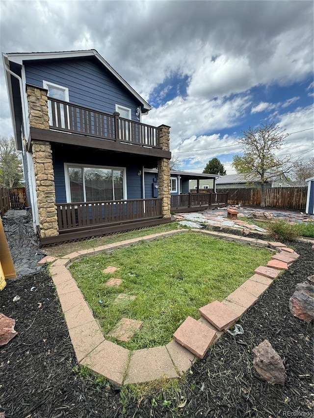 rear view of house featuring a lawn, a patio area, and a balcony