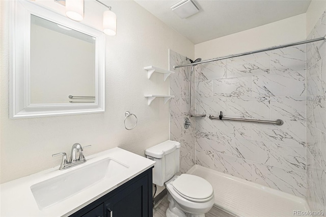 bathroom with vanity, a tile shower, and toilet