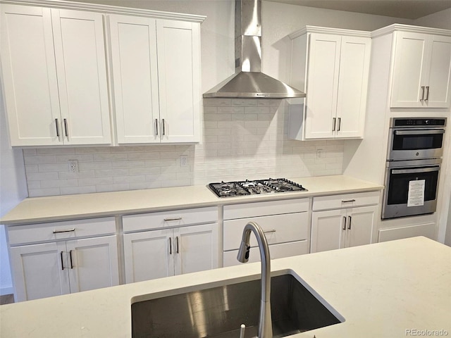 17146 W 92nd Loop, Arvada, CO 80007 - kitchen featuring wall chimney range hood, stainless steel appliances, a sink, and white cabinetry