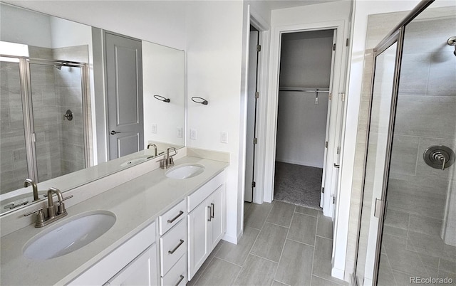 17146 W 92nd Loop, Arvada, CO 80007 - bathroom with a shower stall, a spacious closet, and double vanity