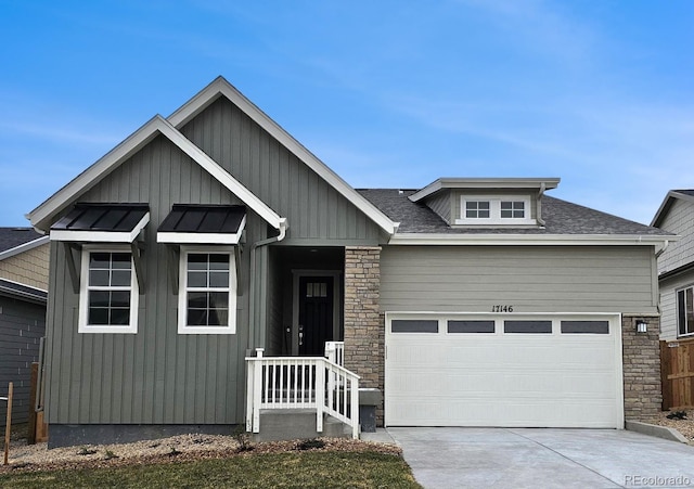 17146 W 92nd Loop, Arvada, CO 80007 - craftsman-style house featuring stone siding, a garage, concrete driveway, board and batten siding, and roof with shingles