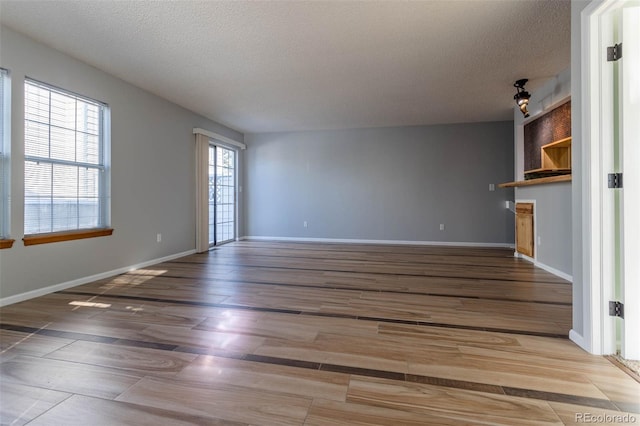 unfurnished living room with hardwood / wood-style flooring and a textured ceiling