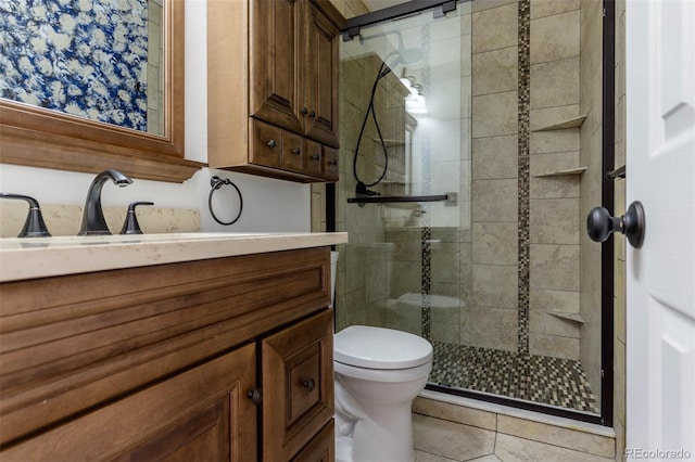 bathroom featuring tile patterned floors, vanity, toilet, and a shower with shower door