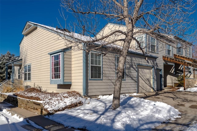 snow covered property featuring a garage