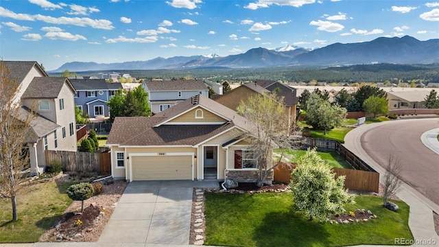 view of front of house with a mountain view, a garage, a residential view, and fence