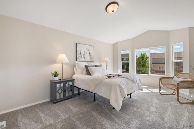 carpeted bedroom featuring lofted ceiling and baseboards