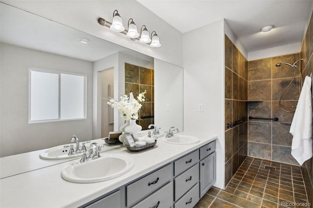 full bath featuring a tile shower and double vanity