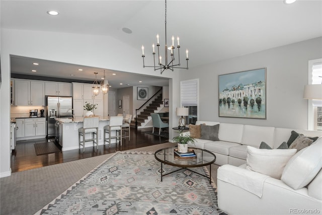 living room featuring lofted ceiling, a chandelier, and dark hardwood / wood-style flooring