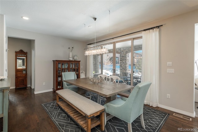 dining space featuring dark hardwood / wood-style floors and a chandelier