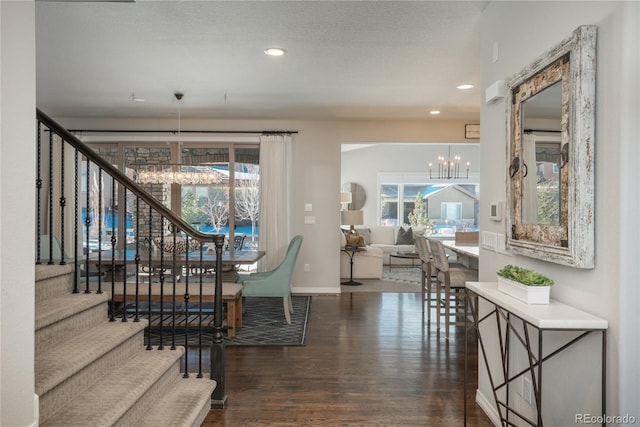 dining room featuring plenty of natural light, dark hardwood / wood-style flooring, a textured ceiling, and a notable chandelier