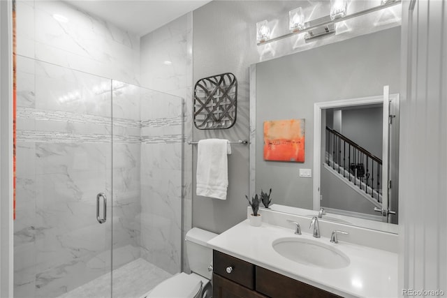 bathroom with vanity, a shower with shower door, and toilet