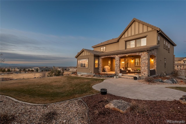 view of front of home with a patio and a lawn