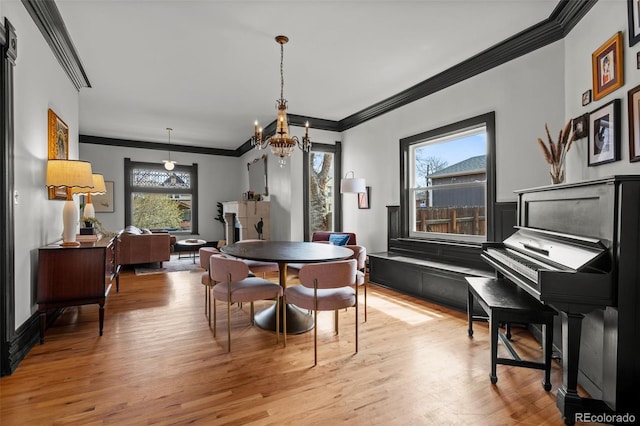 dining room featuring light wood finished floors, a notable chandelier, and ornamental molding