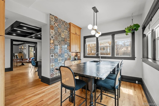 dining room with baseboards, a chandelier, and light wood-style floors