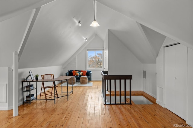 bonus room featuring light wood finished floors and lofted ceiling
